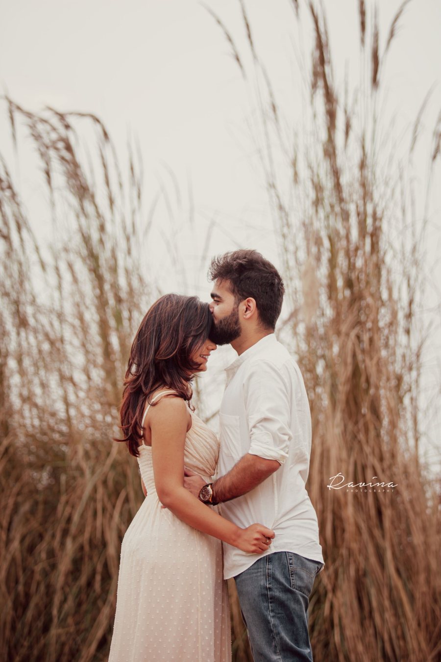 Couple embracing in tall golden grass, Seattle couples photography by Ravina Photography
