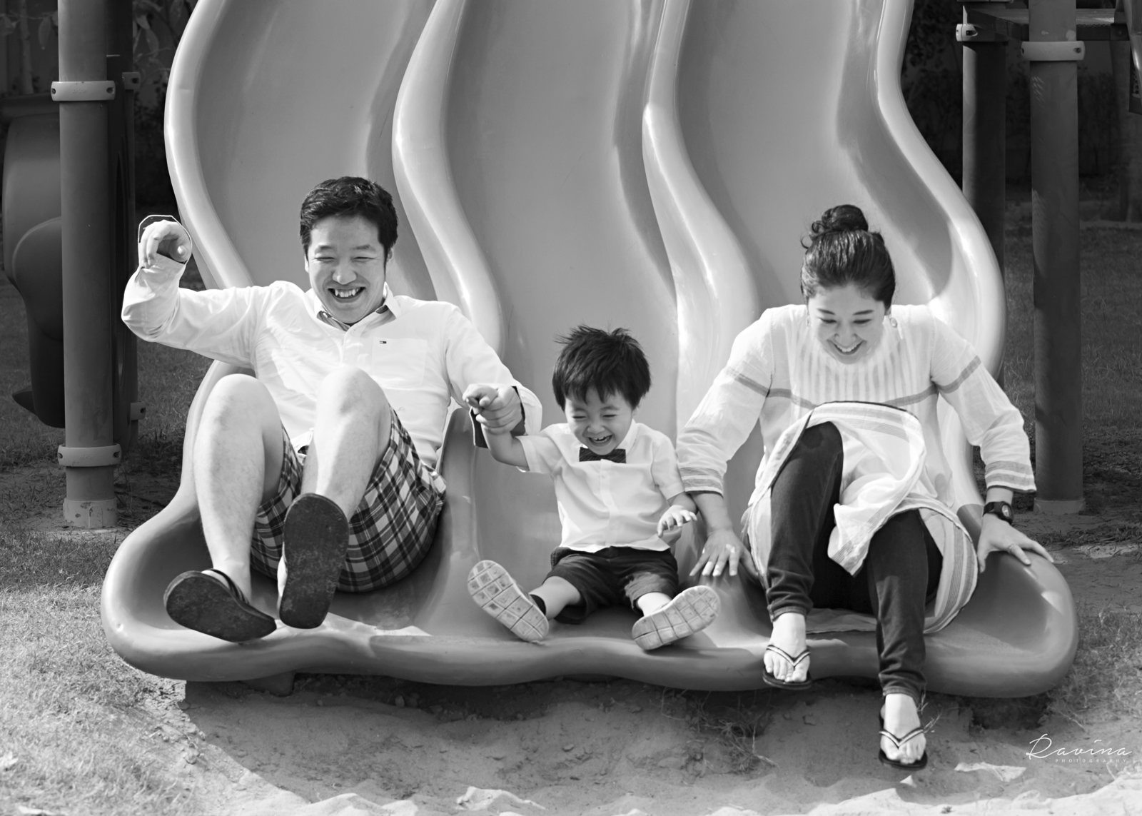 Family laughing together on a playground slide during a Seattle family photography session