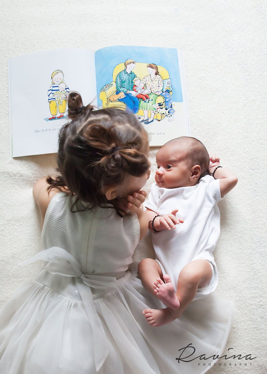 Big sister gazing at her newborn sibling, Seattle newborn photography by Ravina Photography